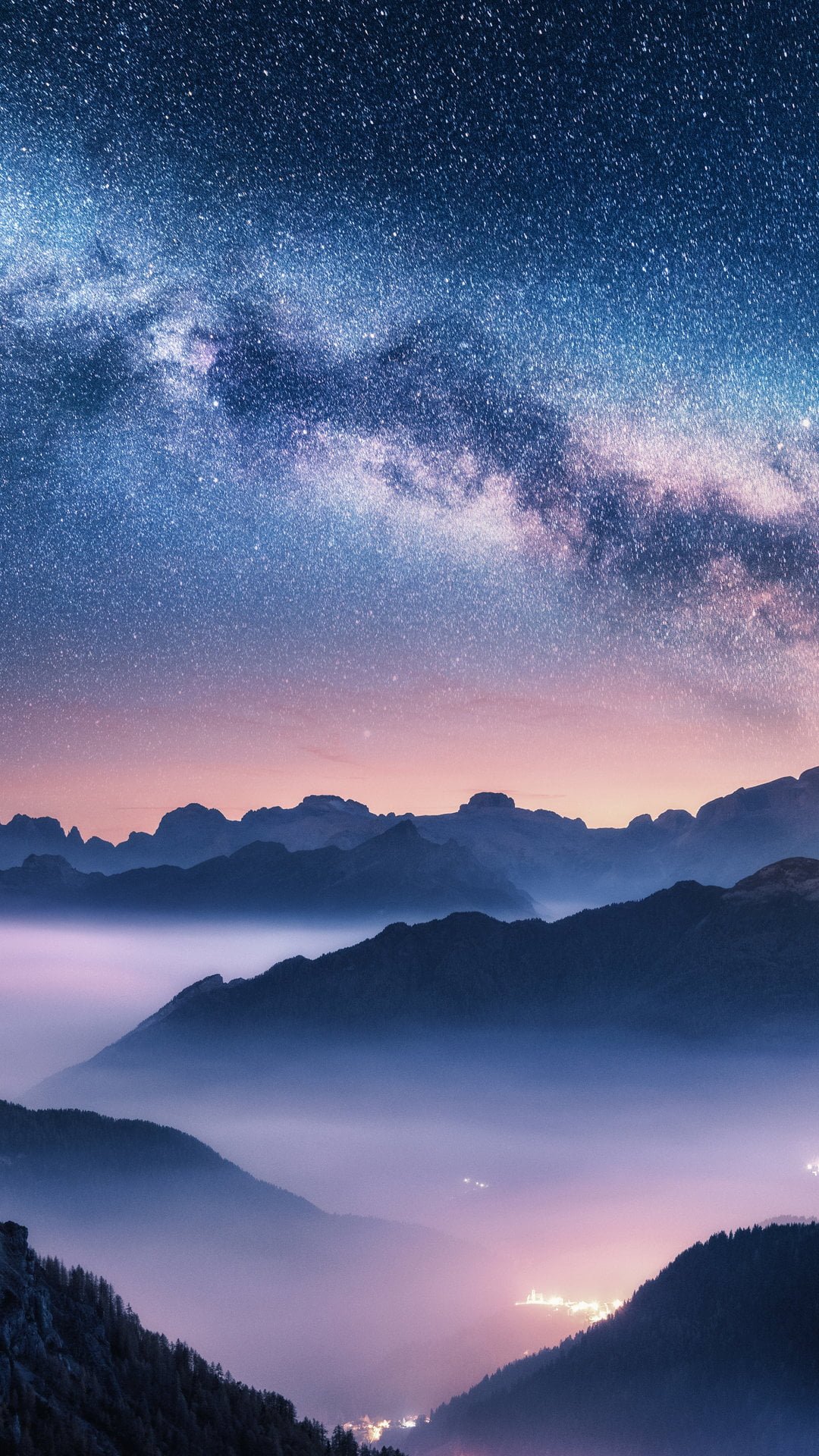 Milky Way over mountains in fog at night in summer